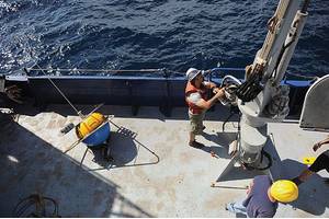 Crew aboard the Office of Naval Research (ONR)-sponsored research vessel (R/V) Melville retrieve a wave buoy during an at-sea demonstration of the Environmental & Ship Motion Forecasting (ESMF) program.